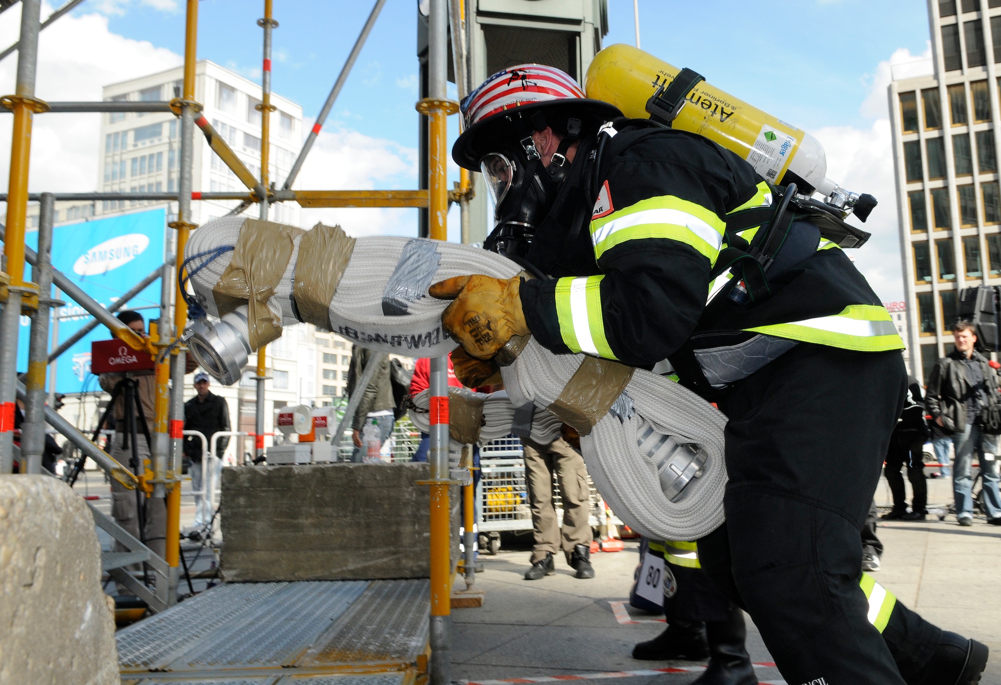 BERLIN – Airman Tyler Lamberson lifts a 45-pound bundle of hose before running up six flights of stairs during his race in the fourth Berlin Firefighter Combat Challenge Sept. 3. Airman Lamberson finished the event in 1 minute, 35 seconds, placing in the top 10 percent of his age division. (U.S. Air Force photo/Staff Sgt. Benjamin Wilson)