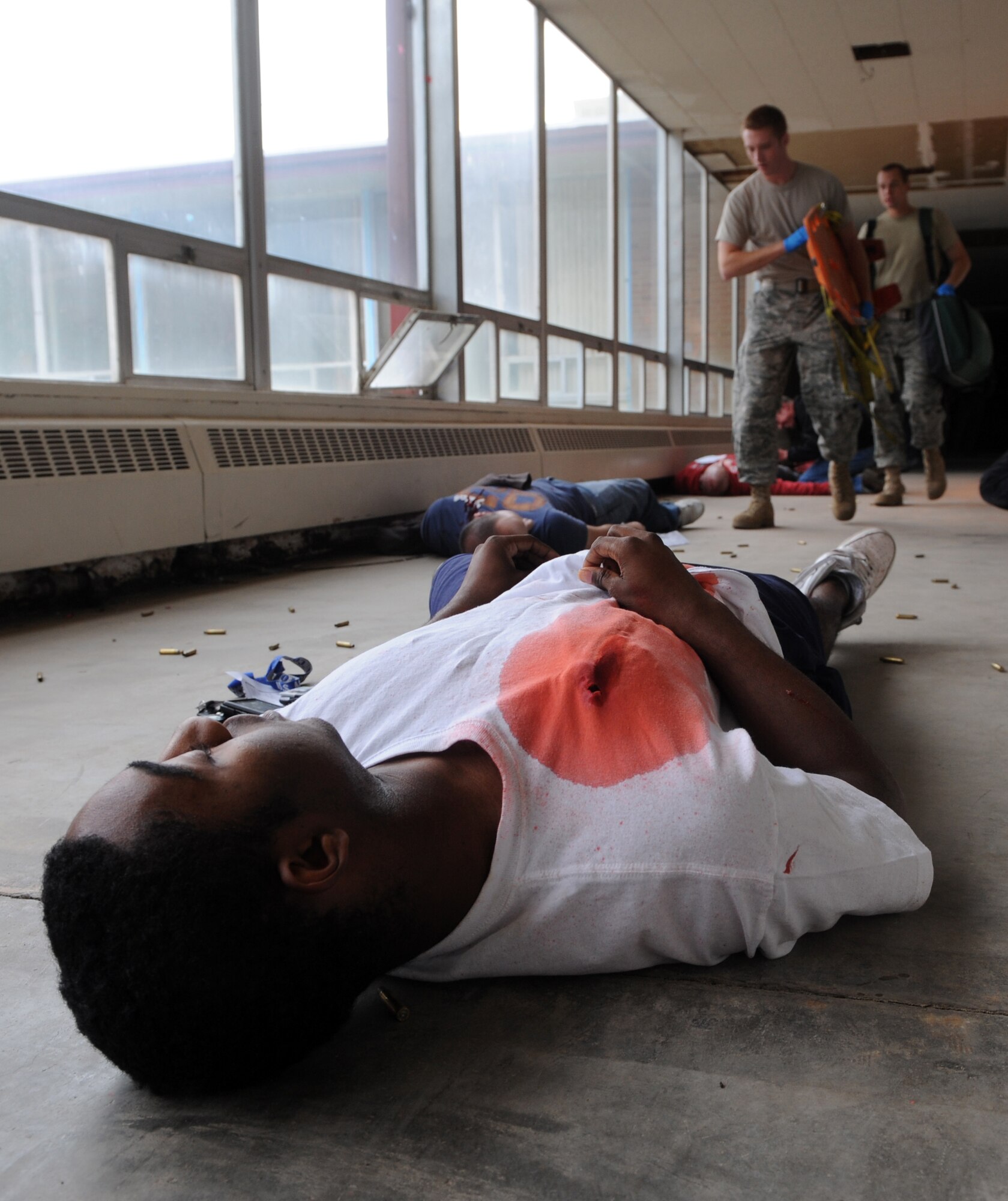 MOUNTAIN HOME AIR FORCE BASE, Idaho – Airman 1st Class Donnell Jackson, 366th Comptroller Squadron, simulates a gunshot wound to the chest as members of the Fire Department arrive on scene at the base primary school during an exercise Sept, 8.  Mountain Home AFB uses simulated exercises to increase their readiness and ability to take appropriate measures to protect our people and resources during real-world situations. (U.S. Air Force photo by Senior Airman Debbie Lockhart)
