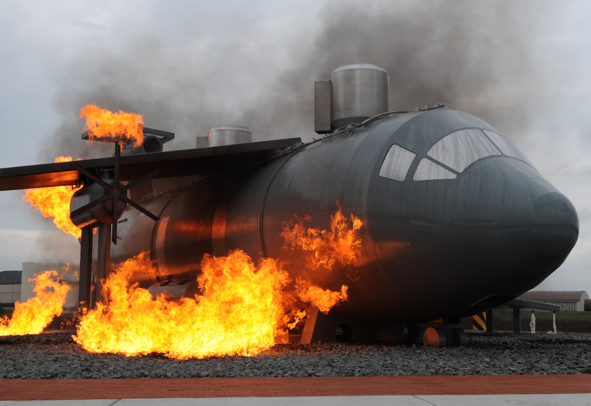A new aircraft fire training burn site is engulfed in flames for construction team members and fire trainers to view, Ramstein Air Base, Germany, Sept. 9, 2010. The new burn site is the only aircraft training site in Germany and will help train in many aircraft scenarios. (U.S. Air Force photo by Senior Airman Caleb Pierce)