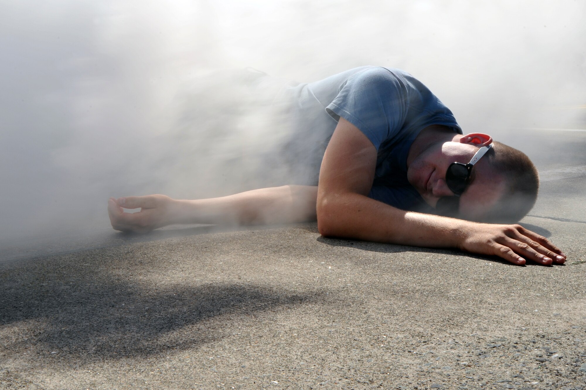 U.S. Air Force Airman 1st Class Gregory Arnolds, 35th Fighter Wing Maintenance Squadron, lies on the ground in a flume of smoke, as a simulated victim during a major accident response exercise at Misawa Air Base, Japan, Sept. 8, 2010. Misawa AB and Japan Air Self-Defense Force combined rescue efforts as part of a joint exercise, which was geared to prepare the base in the event of a mishap during the Misawa Air Festival scheduled for Sept. 19. (U.S. Air Force photo/Tech. Sgt. Russell McBride/Released)