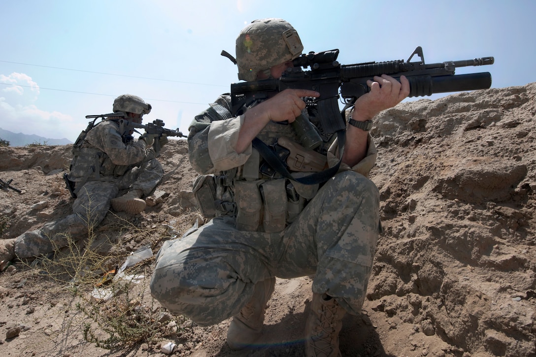 U.S. Army Sgt. David Miller and Spc. Michael Bell scan their sectors after receiving intelligence that insurgents were moving towards the team while they were inspecting a construction project in the Tagab District Center, Kapisa province, Afghanistan, Sept. 2, 2010. Miller and Bell are assigned to the Provincial Reconstruction Team Kapisa.