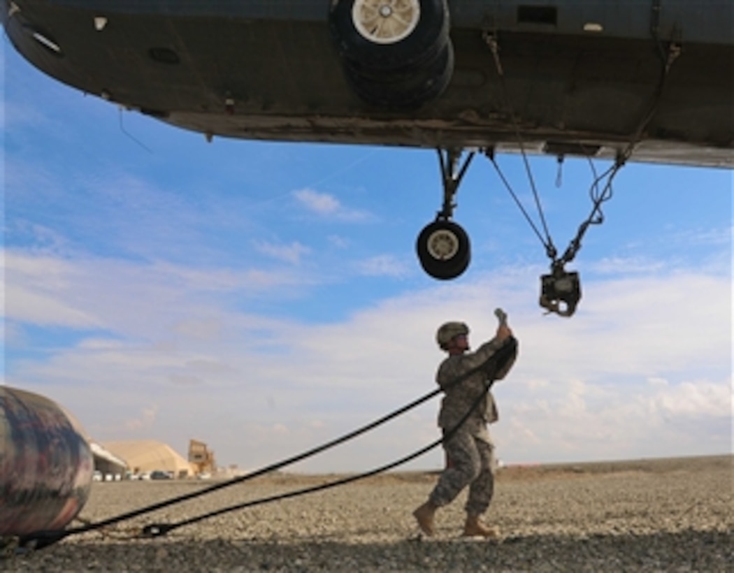 U.S. Army Sgt. Patricia A. O’Connell, a noncommissioned officer in charge of the helicopter landing zone assigned to Company A, 626th Brigade Support Battalion, 3rd Brigade, 101st Airborne Division, prepares to attach a 4,000-pound collapsible fuel bladder to the bottom of a helicopter during an aerial resupply mission at Forward Operating Base Sharana, Paktika province, Afghanistan, on Aug. 7, 2010.  