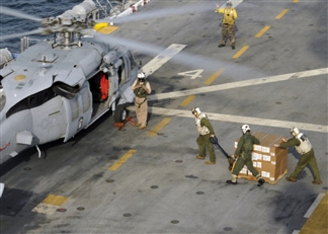 U.S. Marines and sailors load humanitarian assistance disaster relief supplies into a U.S. Navy MH-60S Seahawk helicopter assigned to Helicopter Sea Combat 23 on the flight deck of the amphibious assault ship USS Peleliu (LHA 5) while the ship is underway in the North Arabian Sea on Sept. 6, 2010.  The Peleliu flew 80 pallets of supplies to Sharea Faisal Air Base, Pakistan, for distribution to flooded regions of that country.  The Peleliu is the command ship of the Peleliu Amphibious Ready Group supporting maritime security operations and theater security cooperation efforts in the U.S. 5th Fleet's area of responsibility.  