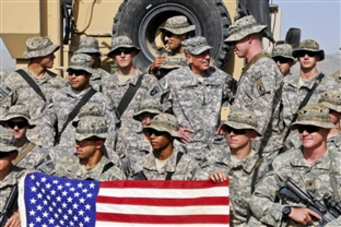 U.S. Army Gen. David H. Petraeus, commander of the International Security Assistance Force in Afghanistan, chats with a soldier after posing for a group photo on Combat Outpost Jaghato, Afghanistan, Sept. 9, 2010. Petraeus visited the base and two combat outposts in the 173rd Airborne Brigade Combat Team's area of responsibility to get first-hand updates on operations and to thank troops for their work. The soldiers are assigned to Company A, 2nd Battalion, 503rd Infantry Regiment.