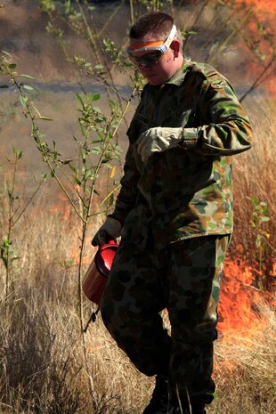 Aircraftman Leigh Weston, firefighter with No. 322 expeditionary Combat Support Squadron, sets a controlled fire here Sept. 9.
