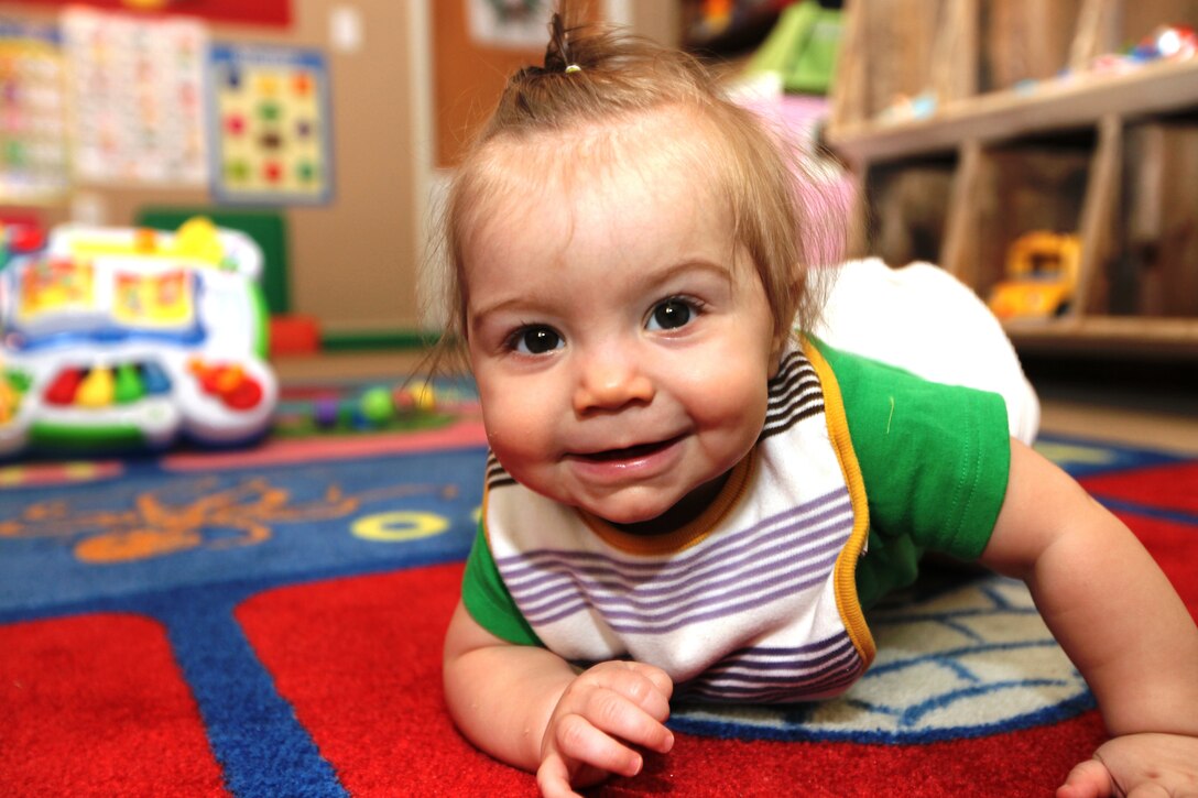 Kinley Nygaard, a 7-month-old enrolled in the Family Child Care Program, crawls around while in her child care provider’s home during the day, aboard Marine Corps Base Camp Lejeune. The FCCP is run by military spouses who live in base housing and have gone through in-depth training to become an approved family child care provider.