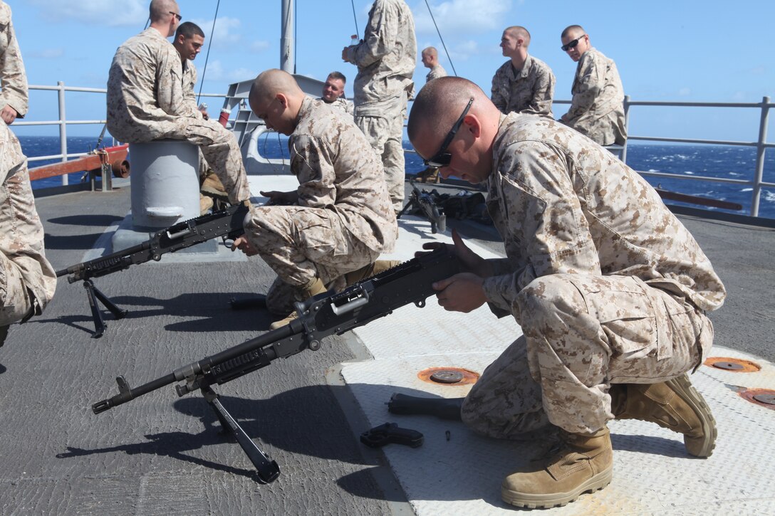 Sergeant Stephan Porter (right) with Company L, Battalion Landing Team 3/8, 26th Marine Expeditionary Unit, breaks down an M240G Medium Machine Gun on the foc'sle aboard USS Carter Hall in the Mediterranean Sea, Sept. 11, 2010. 26th MEU deployed aboard the ships of Kearsarge Amphibious Ready Group in late August responding to an order by the Secretary of Defense to support Pakistan flood relief efforts.