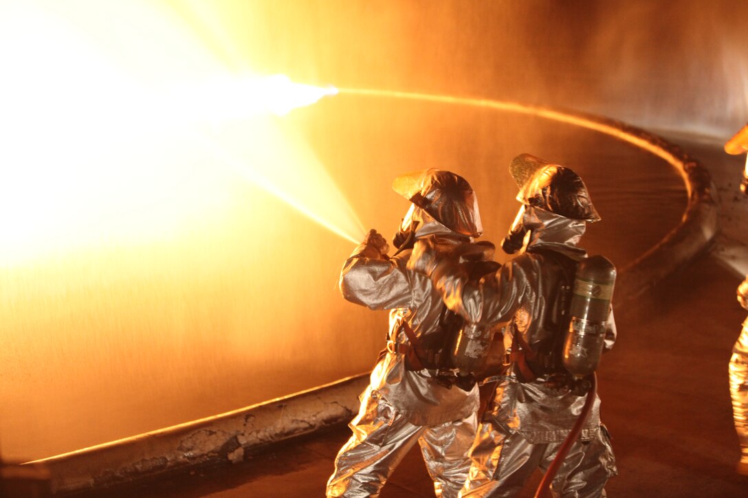 Station Aircraft Rescue and Firefighting Marines dowse a gasoline fire as it erupts during a night fire training exercise at the fuel fire pit Sept. 10. The Marines conducted the training less than 24 hours before Sept. 11, the anniversary of one of the most devastating loss of firefighters the United States has ever seen.