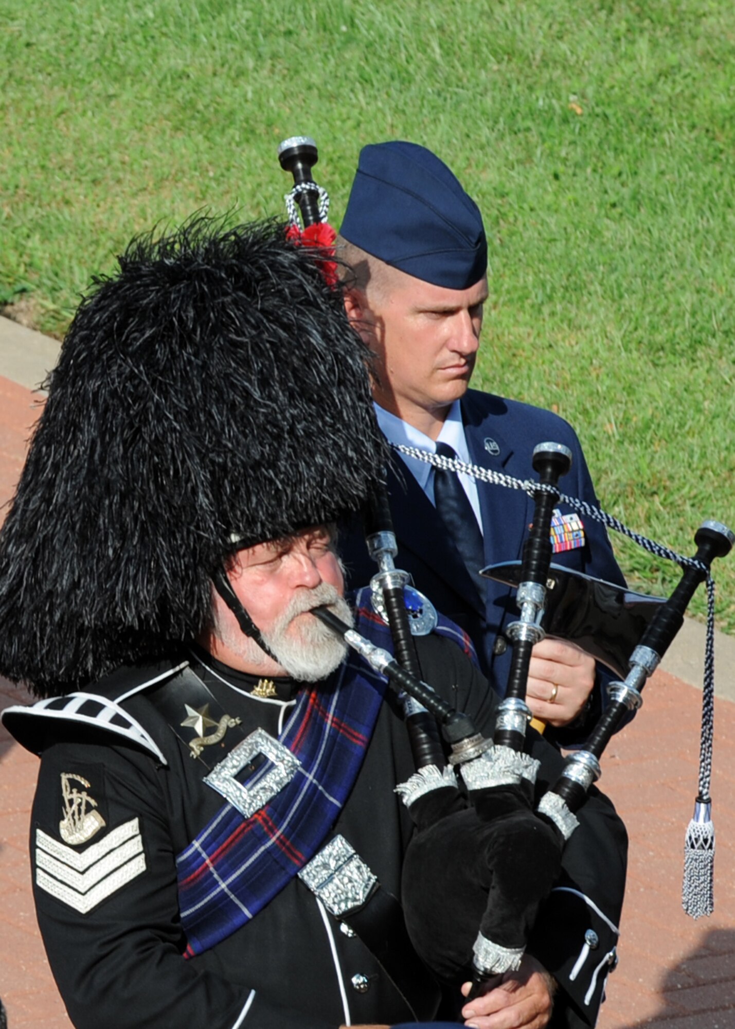 William McCollum, bagpipe player, plays “Amazing Grace” as Staff Sgt. Raymond Gestring, a 22nd Civil Engineer Squadron firefighter, stands in formation during a retreat ceremony at McConnell Air Force Base, Kan., Sept. 10, 2010.   Airmen from McConnell, along with police and fire department representatives from Sedgwick County, Butler County, Wichita, Derby and Rose Hill participated in the ceremony which honored the first responders and civilians who lost their lives during the Sept. 11, 2001, terrorist attacks.  (U.S. Air Force photo/Staff Sgt. Dallas Edwards)