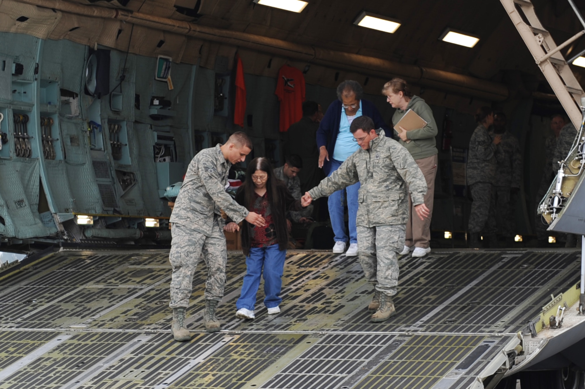 SCOTT AIR FORCE BASE, Ill. -- Team Scott members help an elderly woman down the front of the C-5 Galaxy during the preview air show Sept. 10. The preview air show catered to the elderly and those with special needs.  While the flying portion of the show was canceled due to inclement weather, attendees were able to tour static aircraft, talk with pilots and crew and bounce houses were available for children. (U.S. Air Force photo/Senior Airman Tristin English)