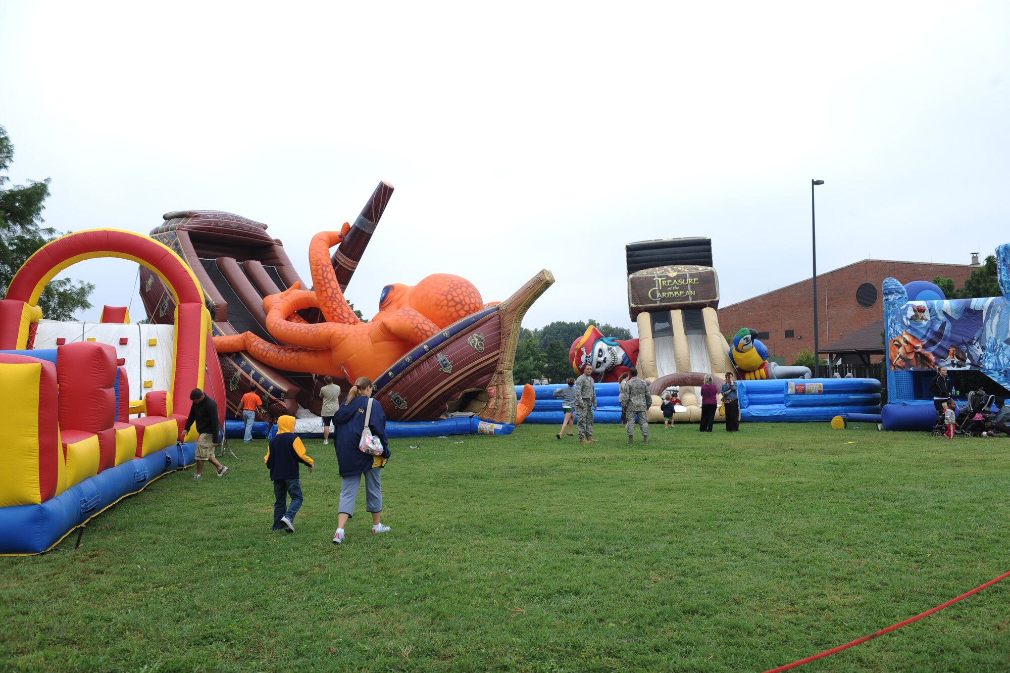 SCOTT AIR FORCE BASE, Ill. -- Children play on inflatable slides Friday afternoon at the flightline at Scott Air Force Base during the preview air show Sept. 10. The preview air show catered to the elderly and those with special needs.  While the flying portion of the show was canceled due to inclement weather, attendees were able to tour static aircraft, talk with pilots and crew and bounce houses were available for children. (U.S. Air Force photo/Senior Airman Tristin English)