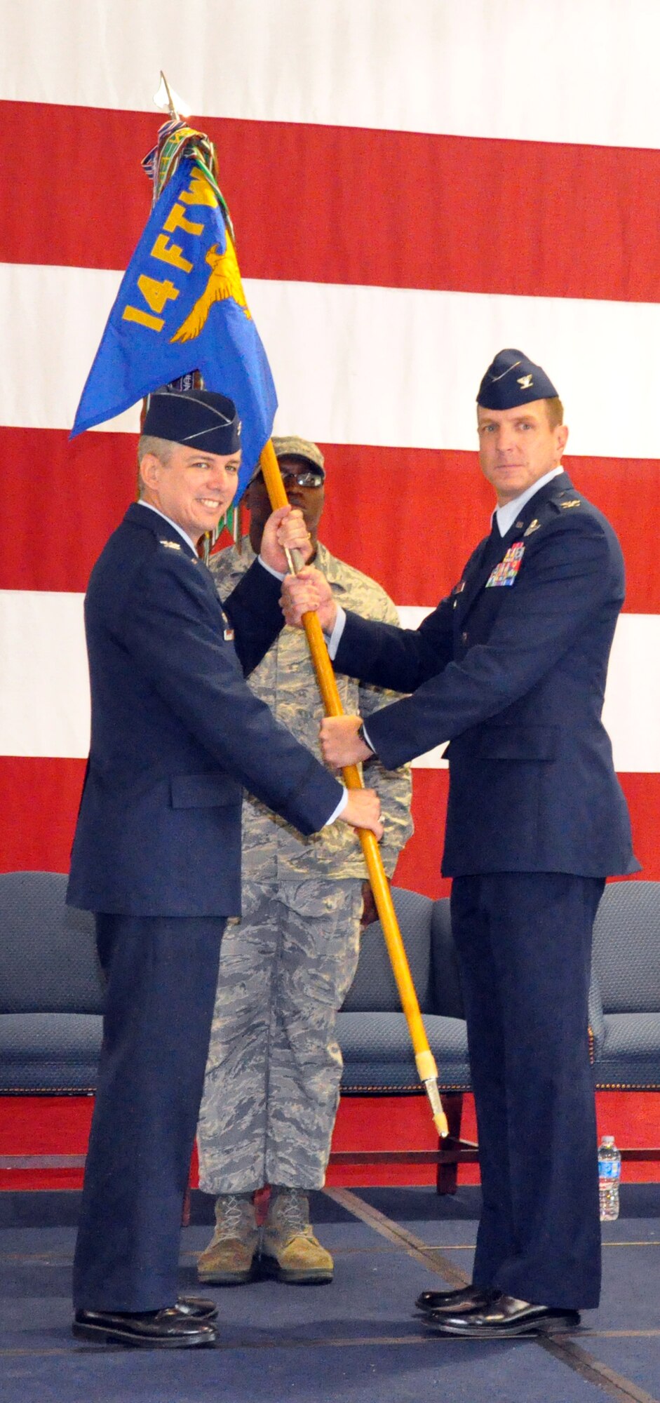 Col. Barre Seguin, 14th Flying Training Wing commander, presents incoming 14th Operations Group Commander Col. Steven Stater with the 14th OG guidon during a formal change of command ceremony Sept. 8 at the BLAZE Hangar here. (U.S. Air Force photo/Staff Sgt. Jacob Corbin). 