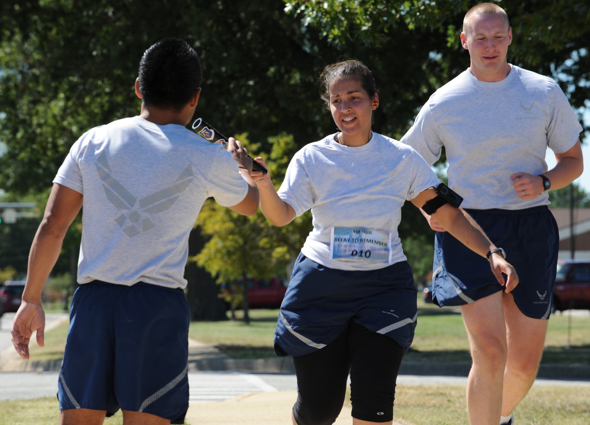 LANGLEY AIR FORCE BASE, Va – Staff Sgt. Stephanie Rosario, and Senior Airman Kevin Buenavides, 438th Supply Chain Operations Squadron team members, exchange the baton during the 9/11 memorial run Sept. 10, 2010. Nine Ten teams, each consisting of 11 people, ran a total of 550 miles with each member running a five-mile loop.  (U.S. Air Force photo/Staff Sgt. Tabitha Kuykendall)(RELEASED)
