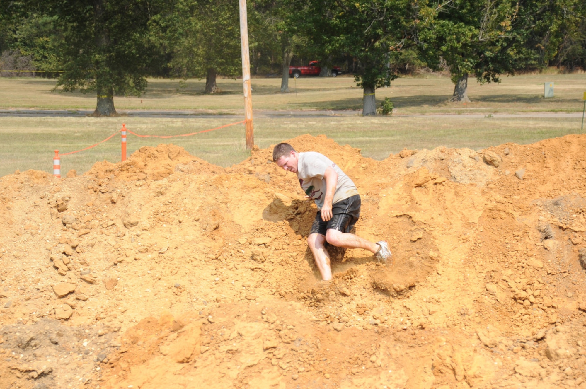 Airman 1st Class Dennis Sloan, 87th Air Base Wing public affairs, slides down a dirt hill into muddy water more than 7 feet below on the “Steeple Chase” obstacle during a test run of the annual “Beast of the East” McGuire Mud Run. The practice was held to ensure all of the obstacles are both safe and challenging for participants of the main event, set to begin at 9 a.m. Saturday. The steeple chase, which is located right before the 5-mile mark, will be open to spectators who wish to cheer runners on. (U.S. Air Force photo/Staff Sgt. Danielle Johnson)