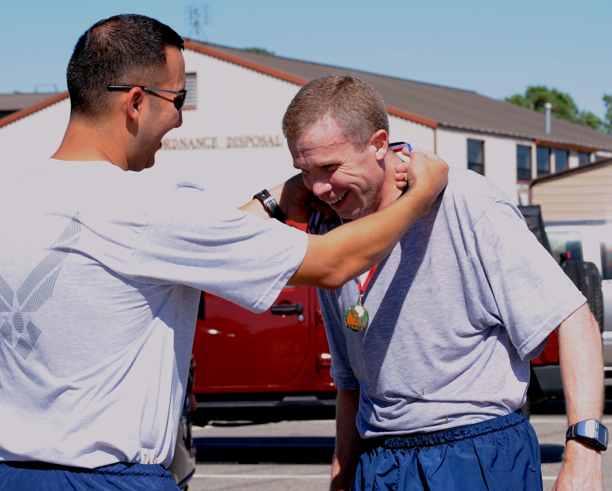 LANGLEY AIR FORCE BASE, Va –  Maj. Joel Fenlason, Headquarters ACC “Team Vorticity” team member, recieves a medal from teammates after finishing the 9/11 memorial run Sept. 10, 2010. Team Vorticity was the first team to have all members cross the finish line, giving them in first place. (U.S. Air Force photo/Staff Sgt. Tabitha Kuykendall)(RELEASED)