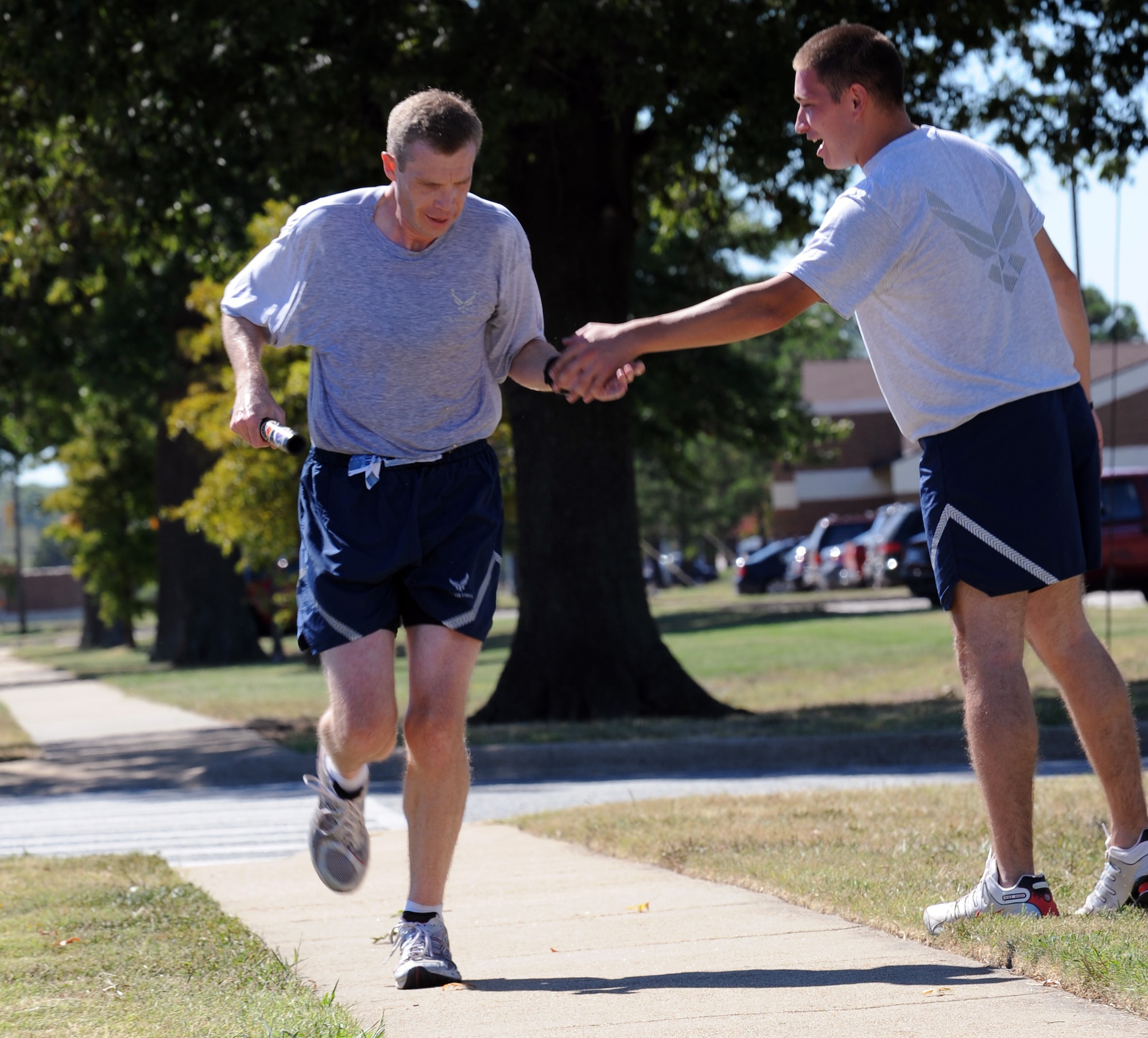 LANGLEY AIR FORCE BASE, Va – SrA Marlon Marros, 9/11 memorial run coordinator, gives Maj. Joel Fenlason, Headquarters ACC “Team Vorticity” team member, a high five as he crosses the finish line of the 9/11 memorial run Sept. 10, 2010. Team Vorticity was the first team to have all members cross the finish line, giving them in first place. (U.S. Air Force photo/Staff Sgt. Tabitha Kuykendall)(RELEASED)