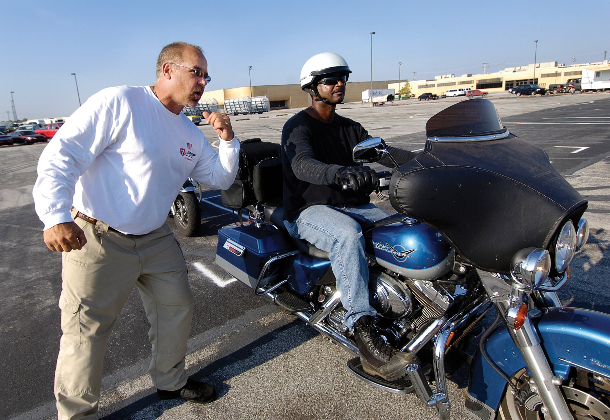 Don Borkoski, a rider coach trainer sent by the U.S. Naval Safety Center, outlines the path of travel for Lt. Col. Reginald Davis, 72nd Air Base Wing, to take his motorcycle through during a course. The goal of the course was to train future coaches to meet the Motorcycle Safety Foundation training demand for both military and civilian riders at Tinker. (Air Force photos by Margo Wright)