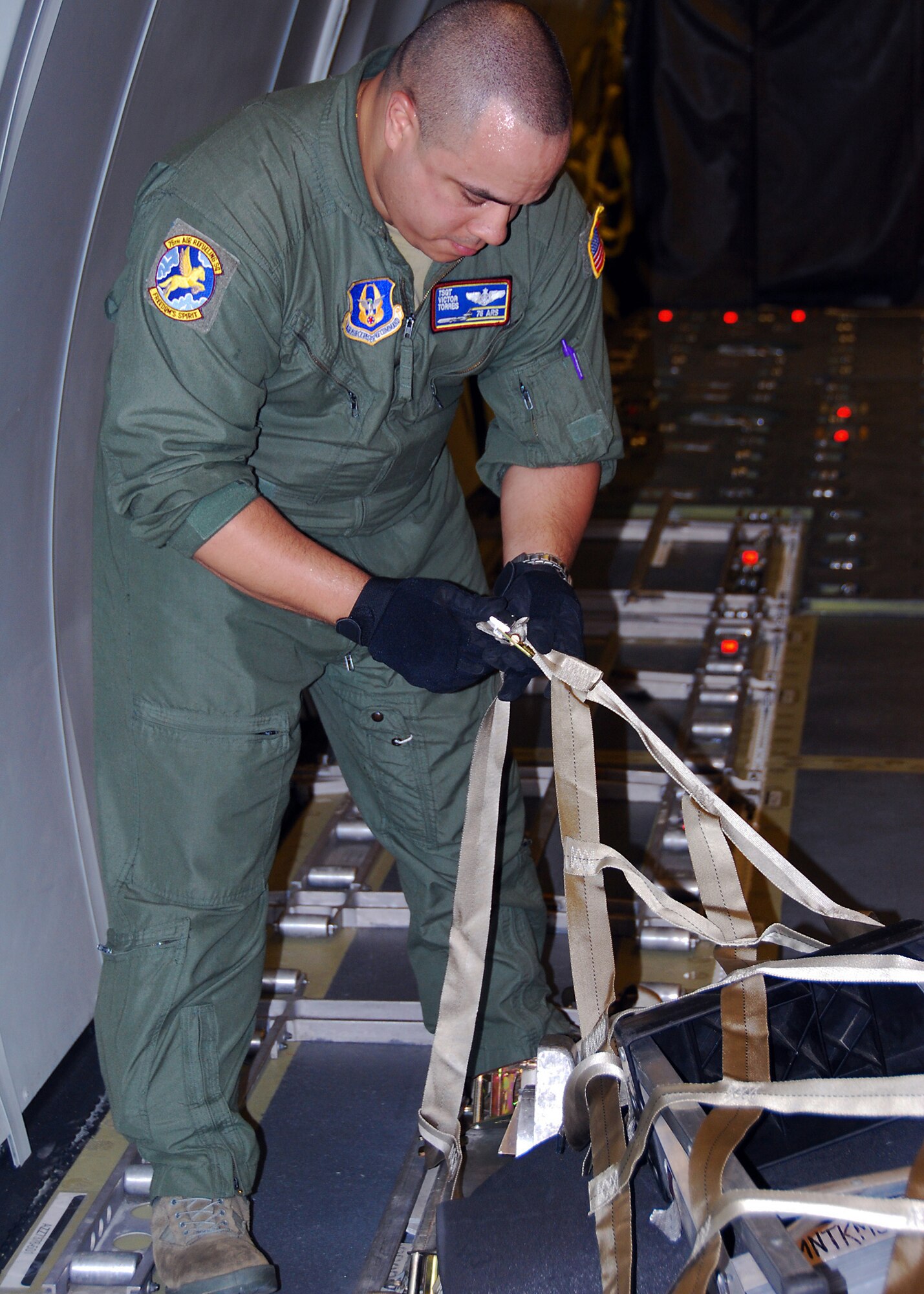 JOINT BASE MCGUIRE-DIX-LAKEHURST, N.J. -- Technical Sgt. Victor Torres, 76th Air Refueling Squadron boom operator, fastens the straps on a KC-10 cargo pallet prior to taking off for a humanitarian mission to Seymour Johnson Air Force Base, N.C. Sept. 2. The mission's objective was to help transport winter gear from Seymour Johnson AFB to orphanages and villages in Afghanistan. It also provided a training opportunity for loading cargo. (U.S. Air Force photo/Staff Sgt. Shawn J. Jones)