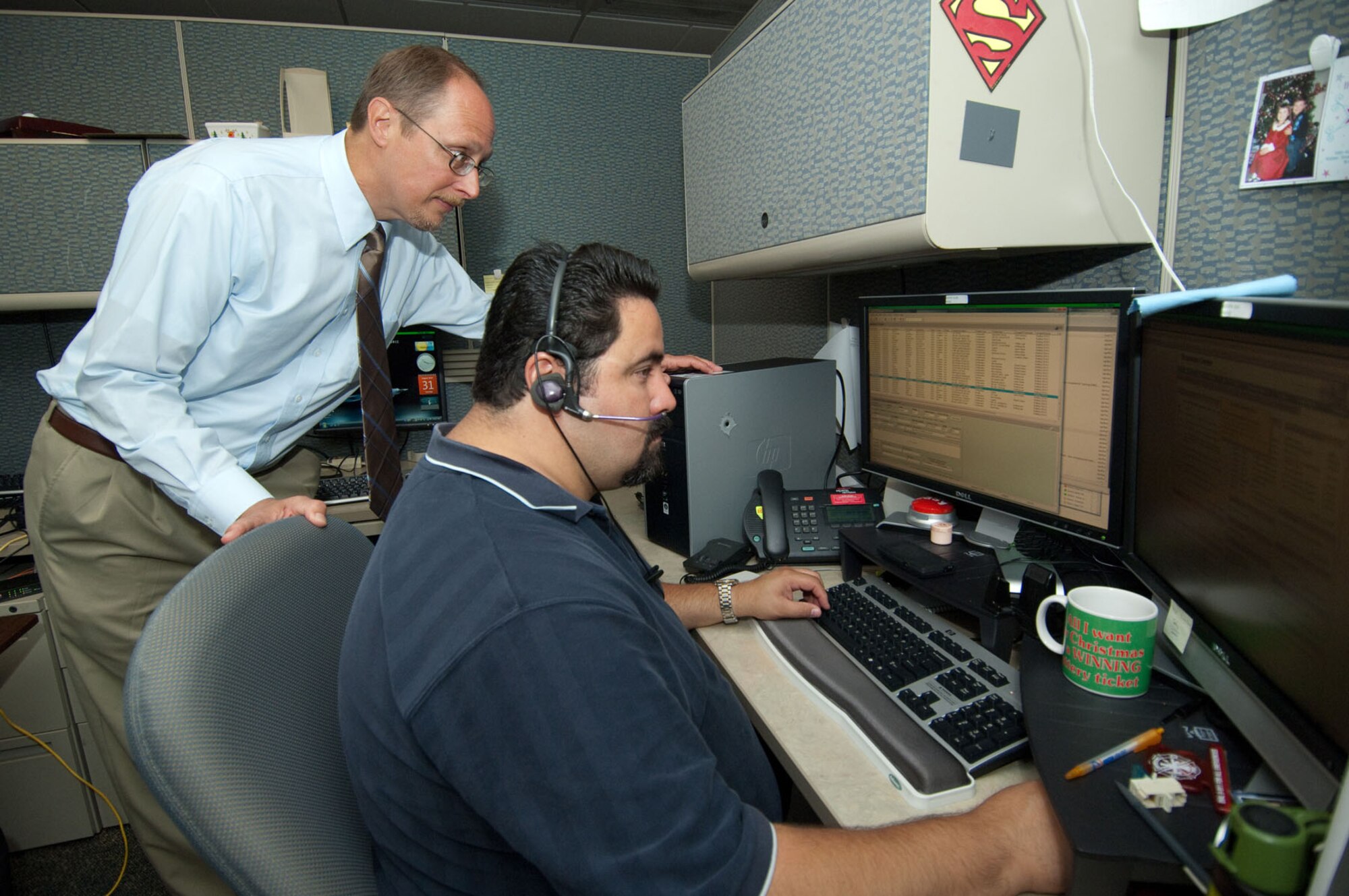 HANSCOM AIR FORCE BASE, Mass. – Rafael Chaires, a client system technician, takes a call from a customer who called 3-HELP while John Moseley, Response Center manager, assists on Aug. 31. Because of recent Air Force mandates, base personnel may soon notice changes to the way they receive IT support. (U.S. Air Force photo by Rick Berry)