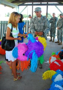 SOTO CANO AIR BASE, Honduras --  Yajaira Matute, a local school teacher, receives piñatas from Staff Sgt. Josue Santiago, of Army Forces, here Sept. 8. Sergeant Santiago and other Joint Task Force-Bravo volunteers filled the piñatas with candy and other treats and delivered them to local school representatives in celebration of Honduras' Children's Day, which takes place Sept. 10. (U.S. Air Force photo/Martin Chahin)