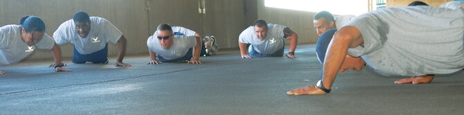 A flight of Airman Leadership School students do push-ups during the 'Tower of Pain' workout on September 1st in the base exchange parking lot located on Luke Air Force Base, Ariz.  According to Staff Sgt. Brian Tisdall, 56th Force Support Squadron Airman Leadership School instructor, 'Tower of Pain' is one fo the hardest workouts ALS does. (U.S. Air Force photo/Airman 1st Class Melanie Holochwost)