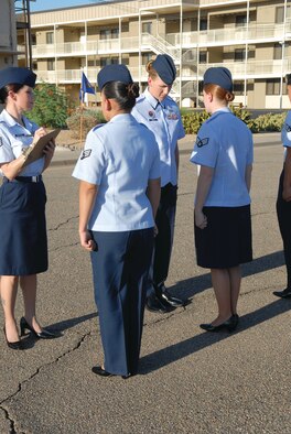Staff Sgt. Lyndsey Lemus, 56th Force Support Squadron Airman Leadership School instructor, conducts uniform inspections on August 23rd as Staff Sgt. Renee Mottola, 161st Air Reserve Wing, takes notes. (U.S. Air Force photo/Airman 1st Class Melanie Holochwost)