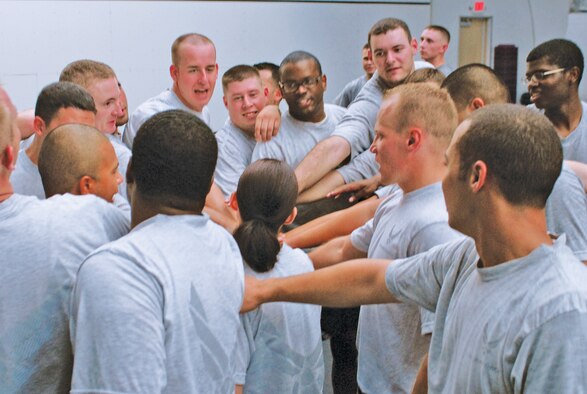 Airman Leadership School students huddle after completing a CrossFit workout in the Luke Combat PT Center.  ALS students participate in a 'Boots and Utes' workout or CrossFit workout every Thursday. (U.S. Air Force photo/Airman 1st Class Sandra Welch)