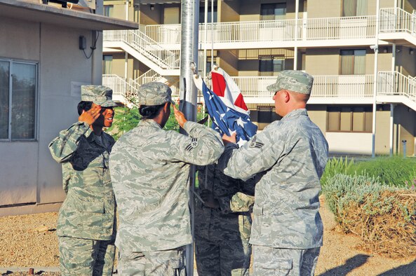 Staff Sgt. Carolyn Russell, 56th Force Support Squadron Airman Leadership School instructor, teaches ALS students how to properly perform flag detail during reveille August 12th in front of Bldg. 156 on Luke Air Force Base, Arizona. (U.S. Air Force photo/Staff Sgt. Steven Nabor)