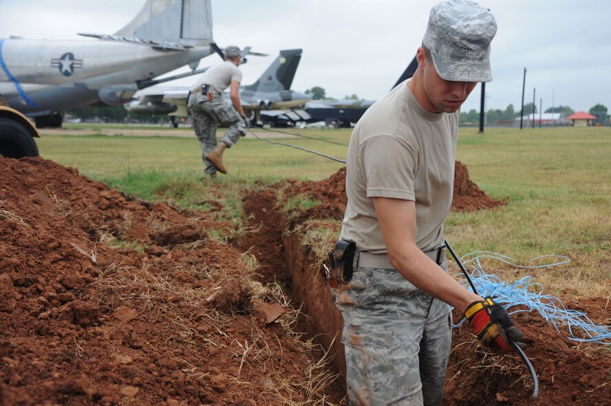 BARKSDALE AIR FORCE BASE, La. -- Airman 1st Class David Montroy, 2nd Communications Squadron antenna systems apprentice and Senior Airman Ezekiel Newman, 2nd CS cable antenna systems journeyman pulls a 12 pair cable through the first hand hole into the manhole so they can be spliced into a 1200 pair cable Sept. 9. The 12 pair feeds a High Frequency hut on the east side of the flight line for radio maintenance. (U.S. Air Force photo by Senior Airman Brittany Y. Bateman)(RELEASED)