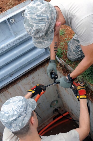 BARKSDALE AIR FORCE BASE, La. -- Senior Airman Ezekiel Newman, 2nd Communications Squadron antenna systems journeyman, and Airman 1st Class David Montroy, 2nd CS cable and antenna systems apprentice tape the pull rope to the cable so that it can be pulled through the innerduct to the other man hole Sept. 9. The 2nd CS most important role is ensuring that the critical systems providing the command and control path for Barksdale?s combatant forces are always ready. (U.S. Air Force photo by Senior Airman Brittany Y. Bateman)(RELEASED)