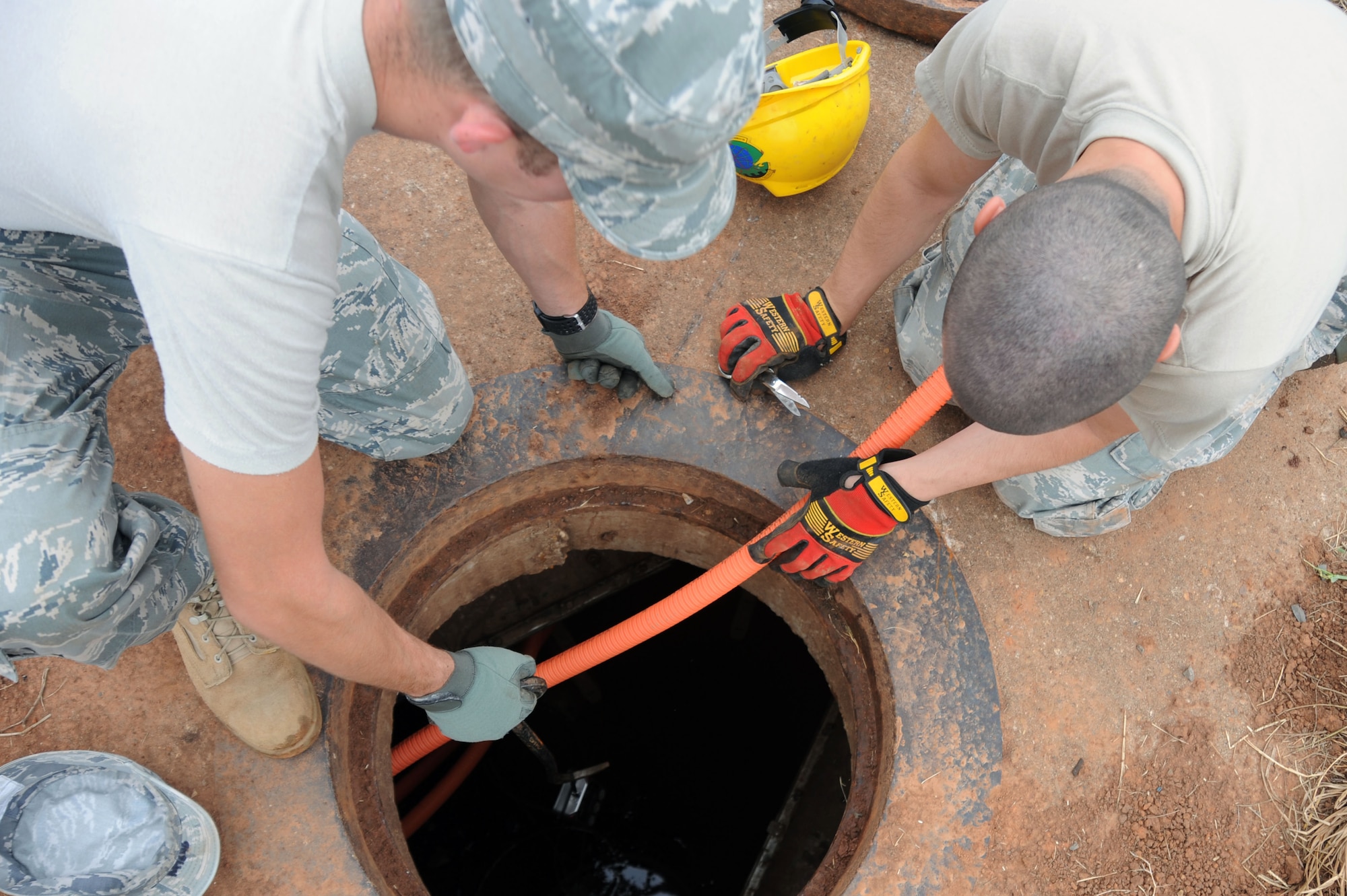 BARKSDALE AIR FORCE BASE, La. -- Senior Airman Ezekiel Newman, 2nd Communications Squadron antenna systems journeyman, and Airman 1st Class David Montroy, 2nd CS cable and antenna systems Apprentice, check the gas levels in a manhole before entering it Sept. 9. Airmen of the 2nd CS provide communications, computer and information management services to the Barksdale community. (U.S. Air Force photo by Senior Airman Brittany Y. Bateman)(RELEASED)