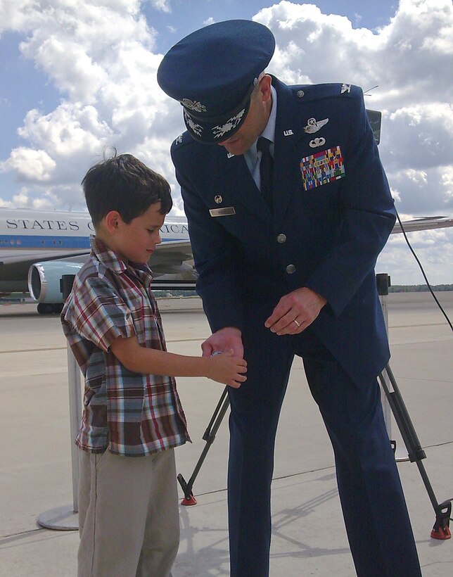 JOINT BASE ANDREWS, Md.-- Colonel Ken Rizer, 316th Wing/Joint Base Andrews commander, presents his coin to Joe Friedman, 8, prior to a presidential mission on Labor Day. Joe is the son of Dave Friedman, Fox News videographer, who filmed the presidential departure from Andrews. (U.S. Air Force Photo by Staff Sgt. Misty D. Slater)