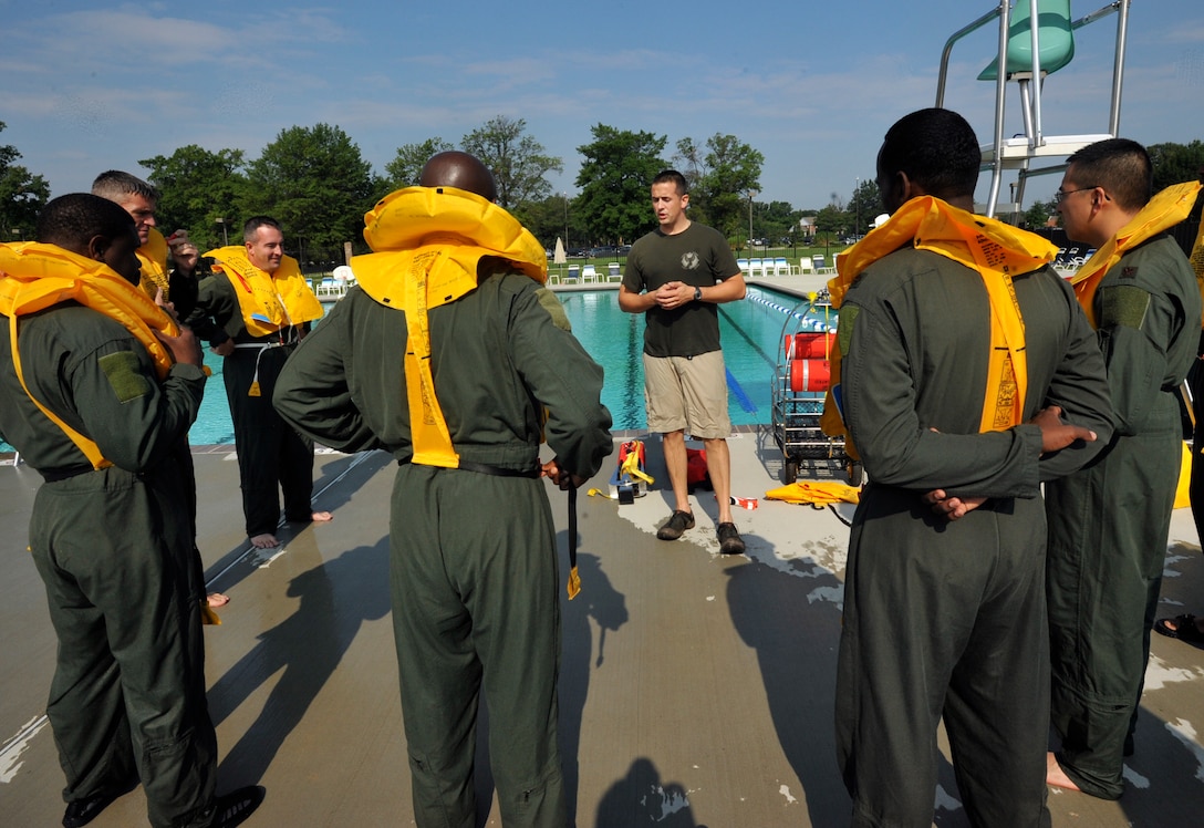 JOINT BASE ANDREWS, Md. -- Staff Sgt. Jonathan McGrath, 89th Operations Support Squadron NCO in charge, Survival Evasion Resistance and Escape informs pilots on getting current coordinates, dispatching mayday alert and passenger brief, prior to ditching the aircraft during water survival training at the base pool Sept. 3. The day-long course also incorporated the pilots who were assigned to the 121st Fighter Squadron, 1st Airlift Squadron, and 99th Airlift Squadron were performing their mandatory tri-annual qualification training. (U.S. Air Force photo by Bobby Jones) 
