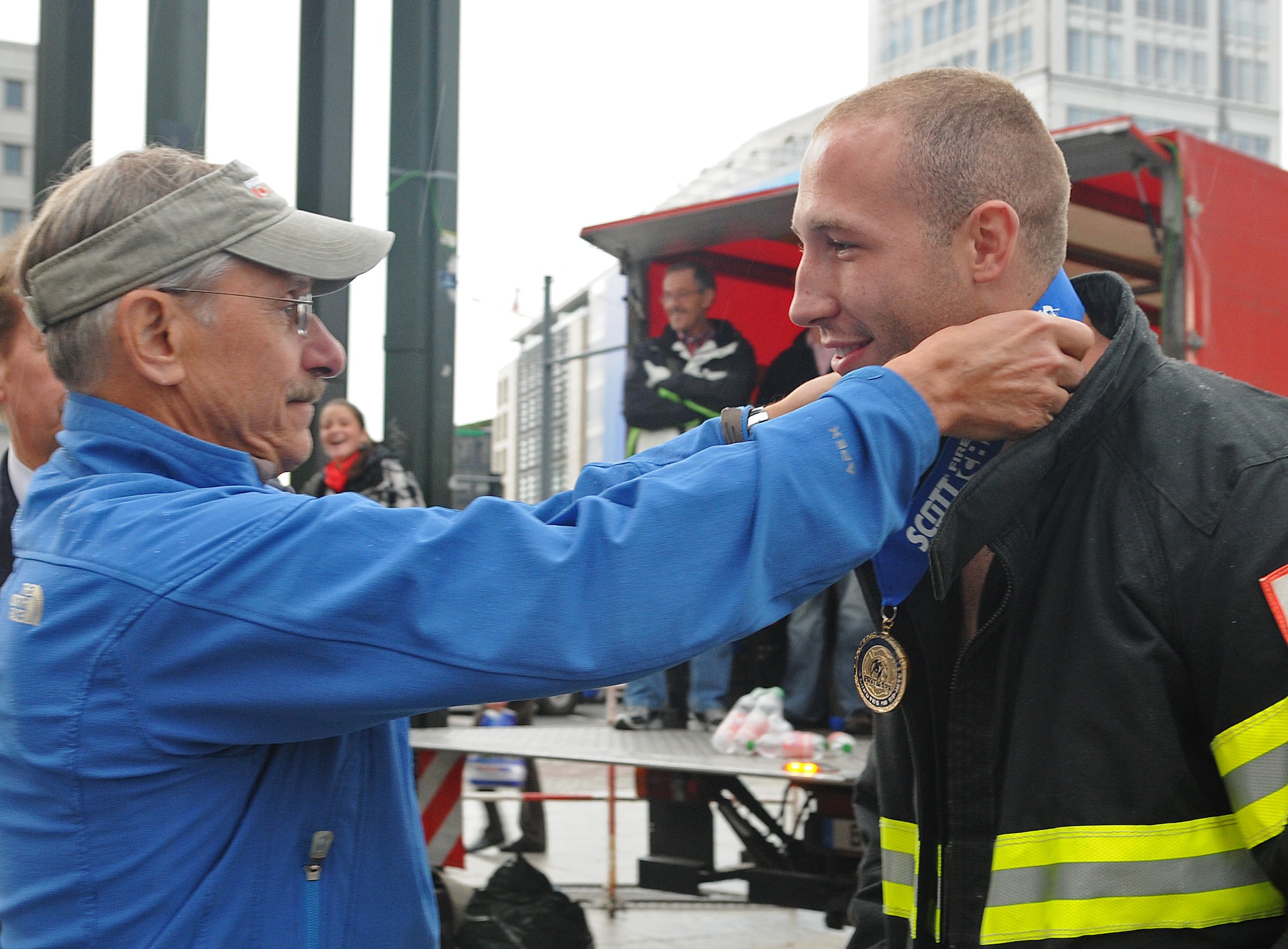 BELRIN – Dr. Paul Davis, Firefighter Combat Challenge creator, hangs a first-place medal on Staff Sgt. Chastin Warner, 52nd Civil Engineer Squadron firefighter, during the award ceremony of the fourth Berlin FFCC Sept. 4. Sergeant Warner earned first place in the event with a time of 1 minute, 44 seconds. (U.S. Air Force photo/Staff Sgt. Benjamin Wilson)