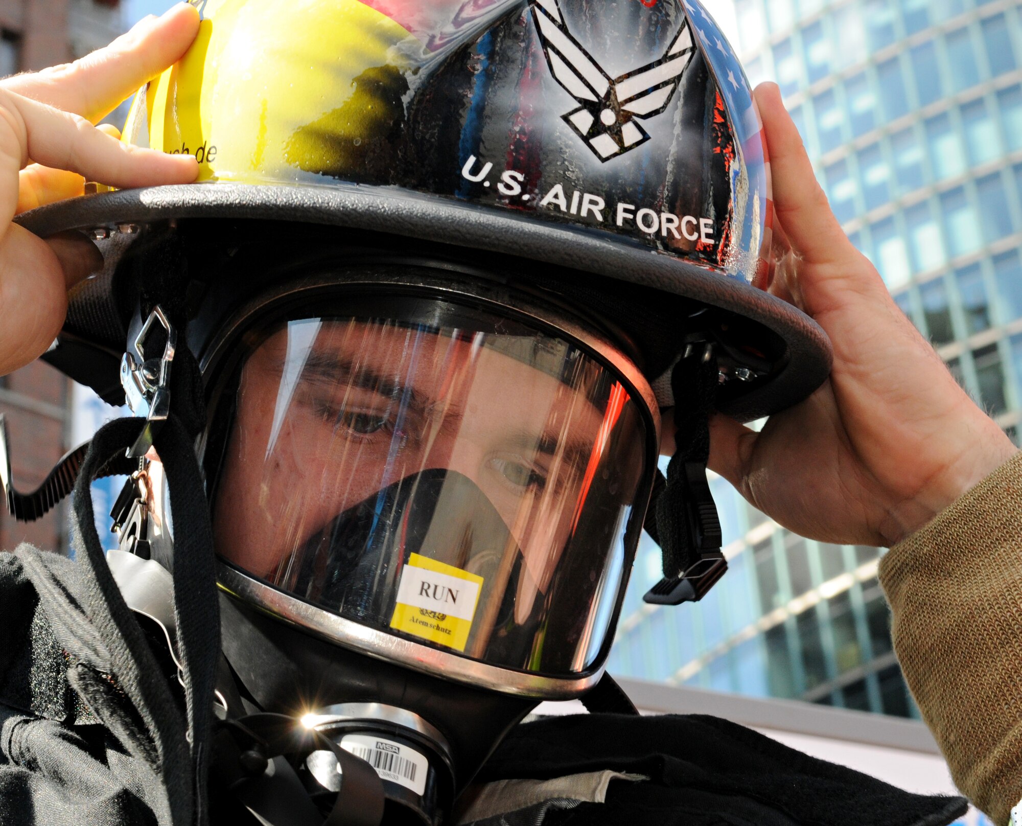 BERLIN – Senior Airman Aaron Anderson, 52nd Civil Engineer Squadron firefighter, dons his helmet before running an individual race in the fourth Berlin Firefighter Combat Challenge Sept. 4. Airman Anderson earned fourth place in the under 30 age group with a finish time of 2 minutes, 7 seconds. (U.S. Air Force photo/Staff Sgt. Benjamin Wilson)