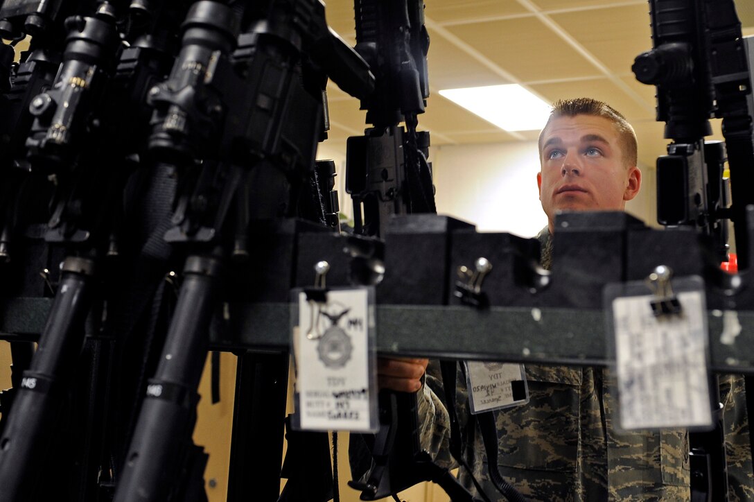 ELLSWORTH AIR FORCE BASE, S.D. -Airman 1st Class Jonathan Sterling, 28th Security Forces Squadron armory attendant, places an M4 carbine onto a rifle rack in the 28th SFS armory, Sept. 8.  Among the many weapons the armory also stores land mobile radios, pepper spray, tactical expandable batons and other items. (U.S. Air Force photo/Staff Sgt. Marc I. Lane)