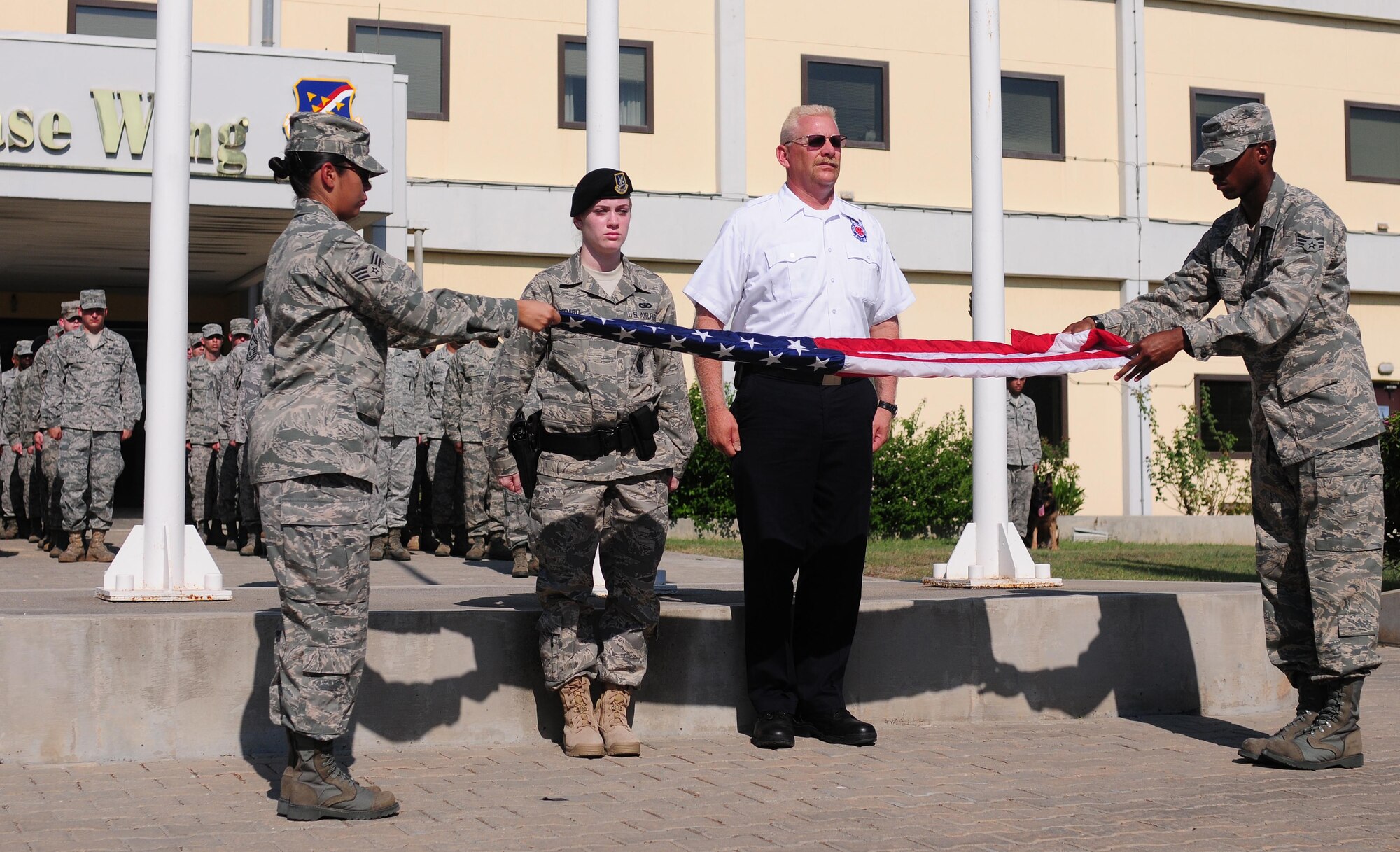 Senior Airmen Gabriela Diaz and Larico Ellis, 39th Medical Operations Squadron, fold a U.S. flag during a Patriot Day retreat ceremony Sept. 10, 2010 at Incirlik Air Base, Turkey.   The ceremony recognized the service of first responders and included a moment of silence and taps to honor those who lost their lives during the Sept. 11 attacks.  (U.S. Air Force photo by Senior Airman Ashley Wood/Released)