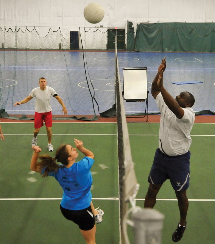 Senior Master Sgt. John Morris, returns a serve to  2nd Lt. Shana L. Drahn-Hoffman, during a volleyball challenge inside the Tactical Fitness Room, at the West Fitness Center Wednesday. The Senior NCOs soundly beat the Company Grade Officer Council in the first game in a series of quarterly ‘fit to fight’ challenges. (U.S. Air Force photo/ Bobby Jones)