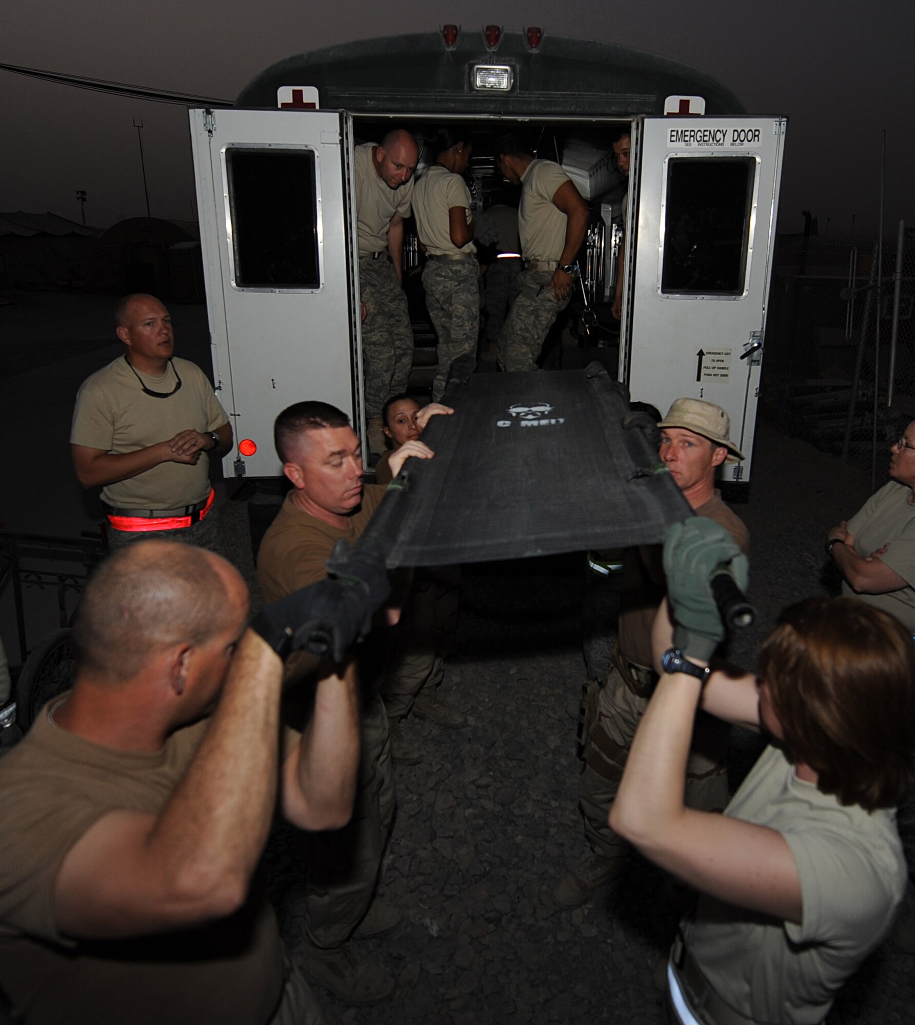 Volunteers practice loading a litter into an ambulance bus during the hands-on portion of a litter-bearing class, Sept. 6, 2010, at Kandahar Airfield, Afghanistan.  Once the volunteers are trained they will be able to volunteer to load patients with the 451st Expeditionary Aeromedical Evacuation Squadron Contingency Aeromedical Staging Facility staff.  (U.S. Air Force photo by Tech. Sgt. Chad Chisholm/Released)
