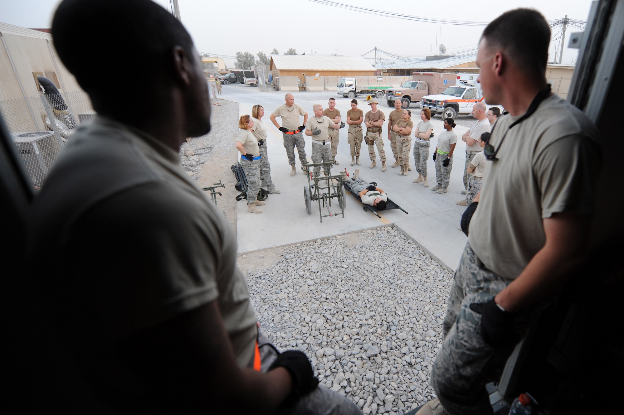 Senior Airman Nikkos Hamlett and Tech. Sgt. Chad North wait to demonstrate the proper procedure for loading a litter in an ambulance bus during training for volunteers, Sept. 6, 2010, at Kandahar Airfield, Afghanistan.  Airman Hamlett is a pharmacy technician and Sergeant North is a medical logistics technician, and are assigned to the 451st Expeditionary Aeromedical Evacuation Squadron Contingency Aeromedical Staging Facility. (U.S. Air Force photo by Tech. Sgt. Chad Chisholm/Released)