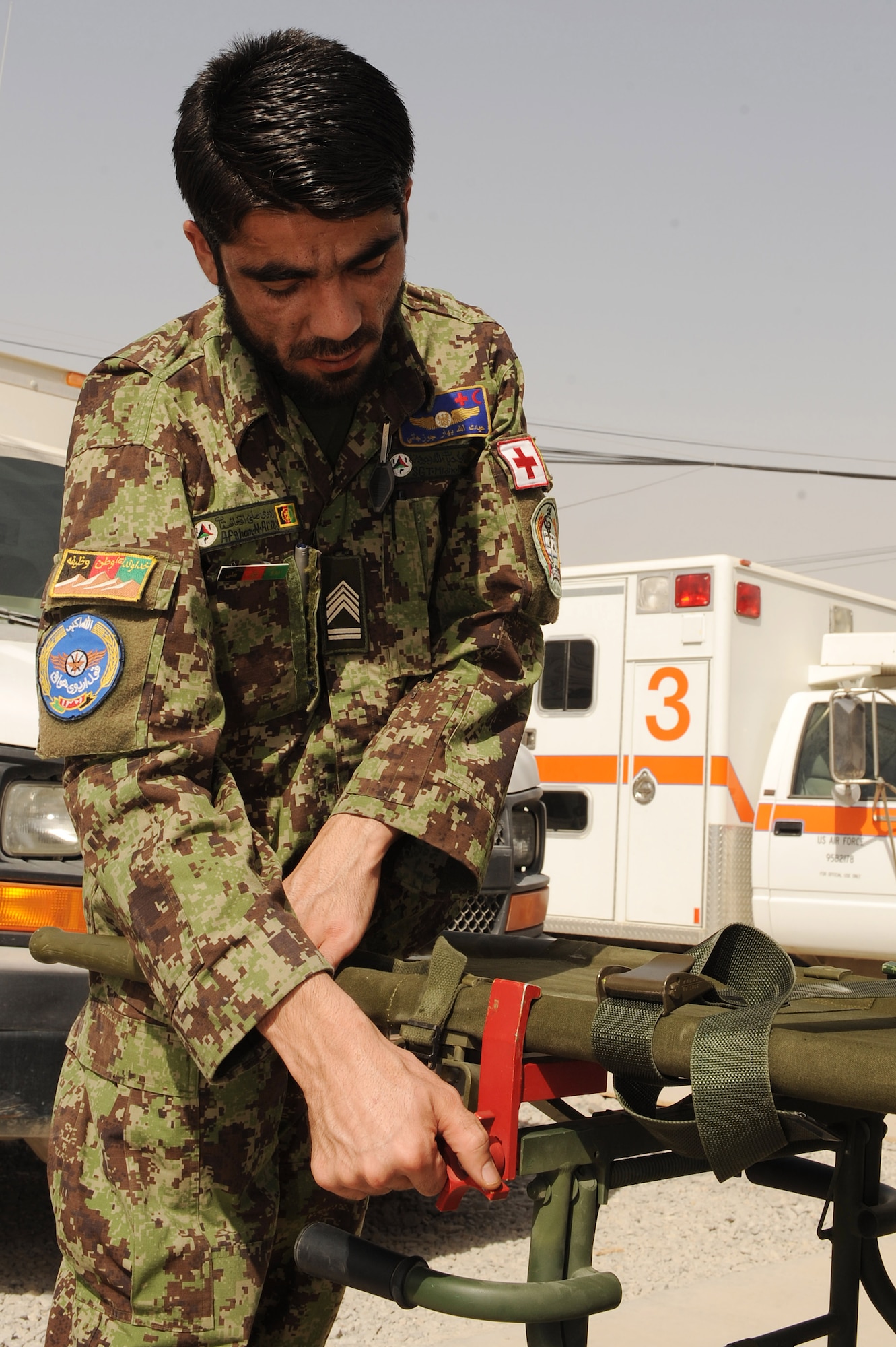 An Afghan flight medic tightens a clamp on a gurney to a patient litter during a patient care concepts orientation offered by the 451st Expeditionary Aeromedical Evacuation Squadron, Sept. 8, 2010, at Kandahar Airfield, Afghanistan. (U.S. Air Force photo by Tech. Sgt. Chad Chisholm/Released)