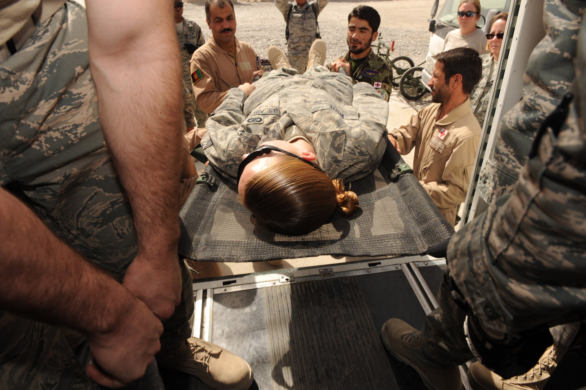 Afghan Air Force flight medics transfer a simulated patient to an ambulance bus during an orientation offered by the 451st Expeditionary Aeromedical Evacuation Squadron, Sept. 8, 2010, at Kandahar Airfield, Afghanistan. (U.S. Air Force photo by Tech. Sgt. Chad Chisholm/Released)