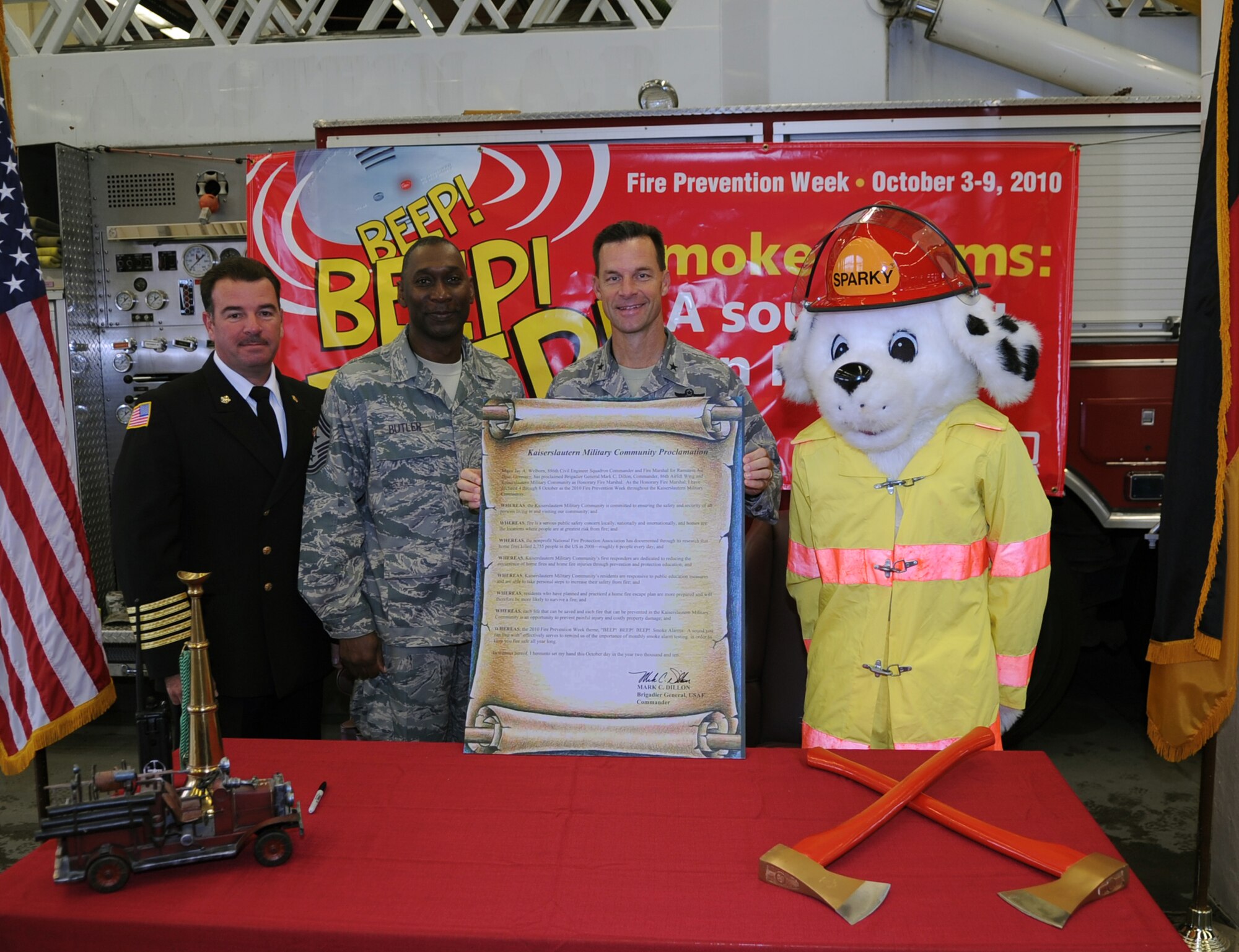 U.S. Air Force Brig. Gen. Mark Dillon, 86th Airlift Wing commander, poses for a photo with Randall Marshall, 886th Civil Engineer Squadron fire chief, Chief Master Sgt. Vernon Butler, 86th Airlift Wing command chief, and Sparky the Fire Dog, after signing the Kaiserslautern Military Community Proclamation, Ramstein Air Base, Germany, Sept. 10, 2010. The signing of the proclamation was to start National Fire Prevention Week, Oct 3-9, with the first week focusing on, "Beep! Beep! Beep! Smoke Alarm; a sound you can live with". (U.S. Air Force photo by Senior Airman Caleb Pierce)