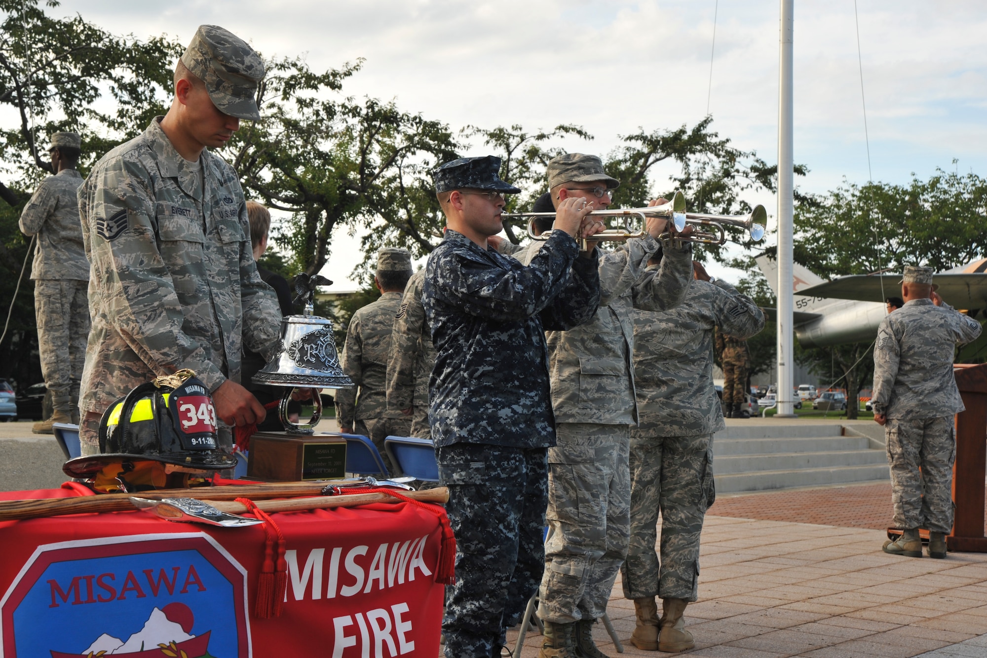 U.S. Air Force Staff Sgt. William Everett, 35th Civil Engineer Squadron left, rings the fire bell, as buglers U.S Navy Seaman Recruit Andrew Waterman, Naval Air Facility, center, and Master Sgt. Dennis Hamm, 35th Maintenance Group, right, play "Taps" during the 9/11 remembrance ceremony.  The ceremony took place at Risner Circle, Misawa Air Base, Japan, Sept. 10, 2010.(U.S. Air Force photo/Tech. Sgt. Russell McBride/Released)