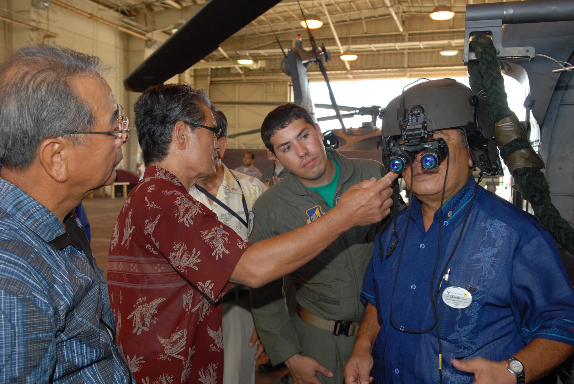 Mr.Isamu Inamine, from the Okinawa Electric Power Company and 18th Comptroller Squadron Co-Commander, checks out night vision goggles while touring the 33d Rescue Squardron Sept. 10. Dozens of Co-Commanders' visited the base to enhance their understanding of Kadena operations. (U.S. Air Force Photo/Junko Kinjo)