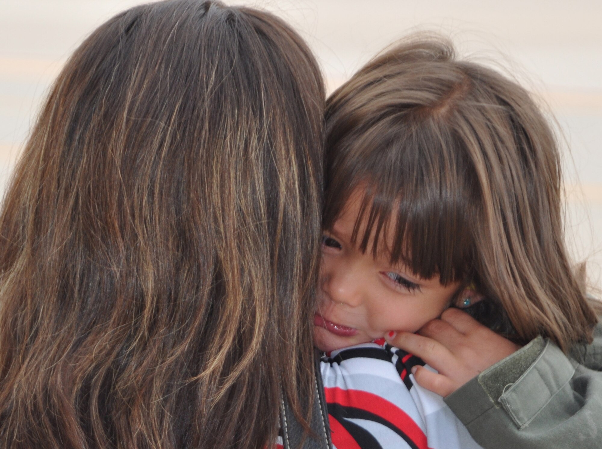 Kimberly Cross (center) comforts daughter Isabella after her father, Air Force Reserve Staff Sgt. Eric Cross, departed for a deployment to the Middle East Sept. 8 from Peterson Air Force Base, Colo. Sergeant Cross, a C-130 Hercules loadmaster, was one of approximately 50 302nd Airlift Wing members who deployed in support of U.S. Central Command operations. More than 150 aircrew, maintenance and support AF Reservists from the 302nd AW departed for deployment through Sept. 9. The AF Reserve's 302nd AW is based at this southern Colorado installation. (U.S. Air Force photo/Staff Sgt. Stephen J. Collier)