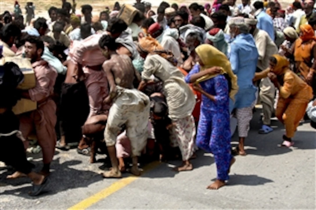 Pakistani flood victims pick up relief supplies delivered by U.S. Marines during humanitarian relief efforts in Pano Aqil, Pakistan, Sept. 9, 2010. The Marines are assigned to the 26th Marine Expeditionary Unit.