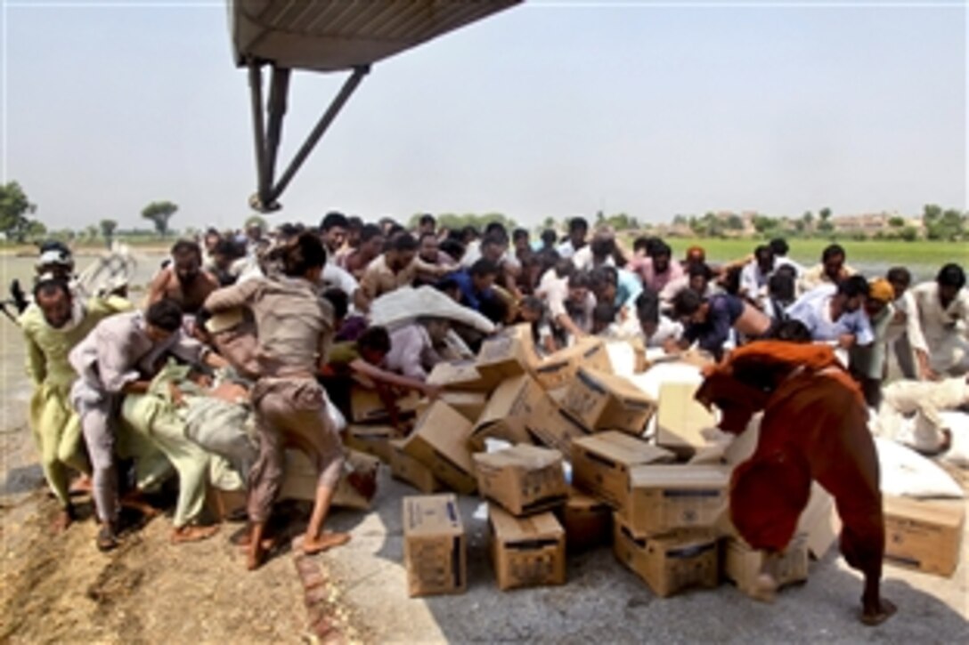 Pakistani flood victims rush to pick up relief supplies delivered by U.S. Marines during humanitarian relief efforts in Pano Aqil, Pakistan, Sept. 9, 2010. The Marines are assigned to the 26th Marine Expeditionary Unit.