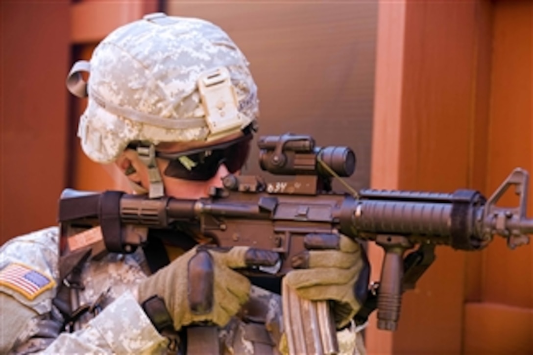 U.S. Army Spc. Christopher Hakathorn, an infantryman from 1st Battalion, 181st Infantry Regiment, Massachusetts National Guard, provides security from a doorway of the urban warfare range at Camp Atterbury Joint Maneuver Training Center in central Indiana, on Aug. 24, 2010.  Hakathorn, along with roughly 600 other U.S. soldiers from 181st Infantry Regiment, are part of one of the largest Massachusetts Guard troop deployments since World War II.  