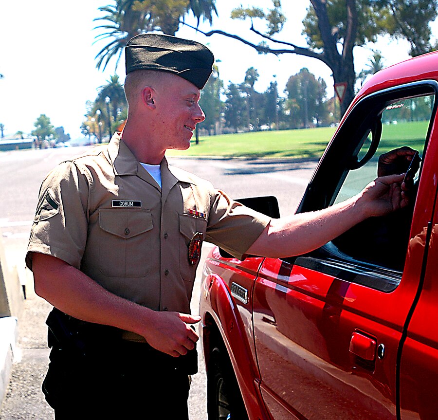 Lance Cpl. Nathaniel D. Corum, military police, Provost Marshal’s Office, works as gate sentry, greeting and checking the drivers DoD decal and identification Sept. 2, ensuring only authorized individuals come aboard the depot.